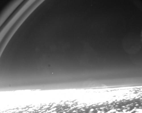 Earth's surface at the bottom and a bright spot (Salsa-C2 satellite)